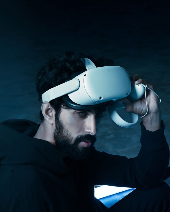 Portrait of a man using VR headset, exploring virtual reality in a futuristic setting.