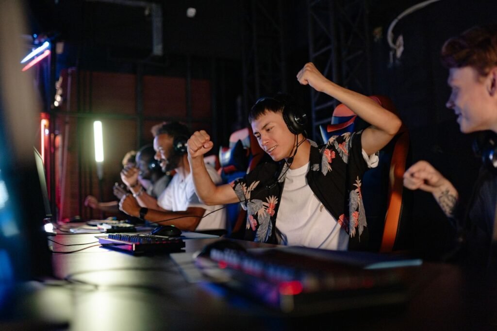 Current image: Excited gamers celebrating a win in a competitive gaming tournament with headphones.